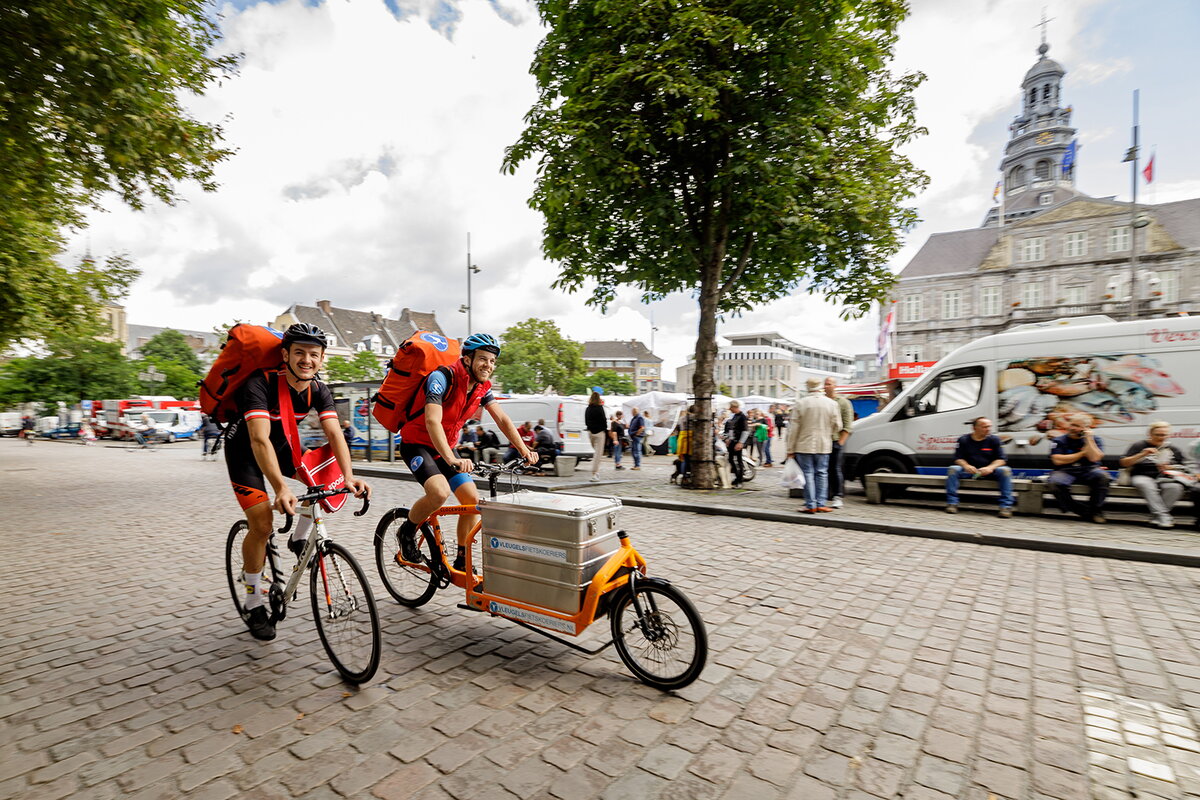 Fietskoeriers Vleugels onderweg met pakket in rugzak en op cargobike in Maastricht