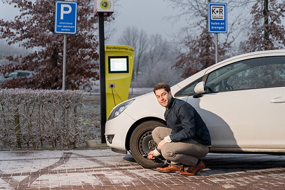 Rob Smeets heeft een pomp aangesloten op de autoband van zijn witte auto