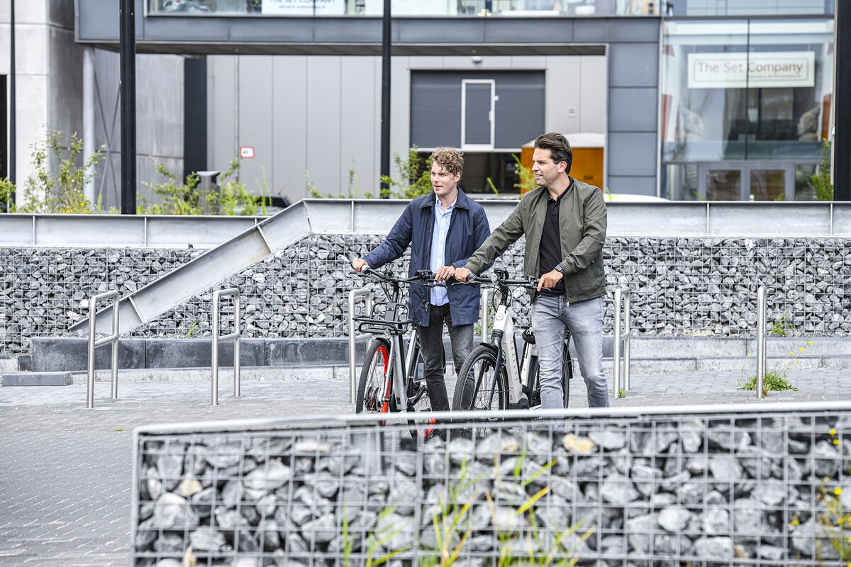 Deelfietsen Hely twee mannen lopen weg met fietsen