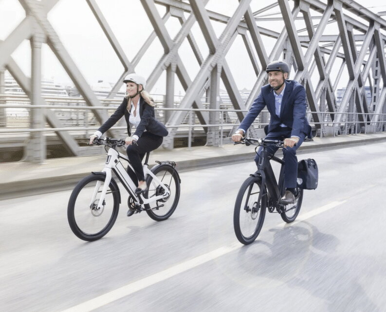 Hellorider twee mensen, man en vrouw, fietsen op een brug
