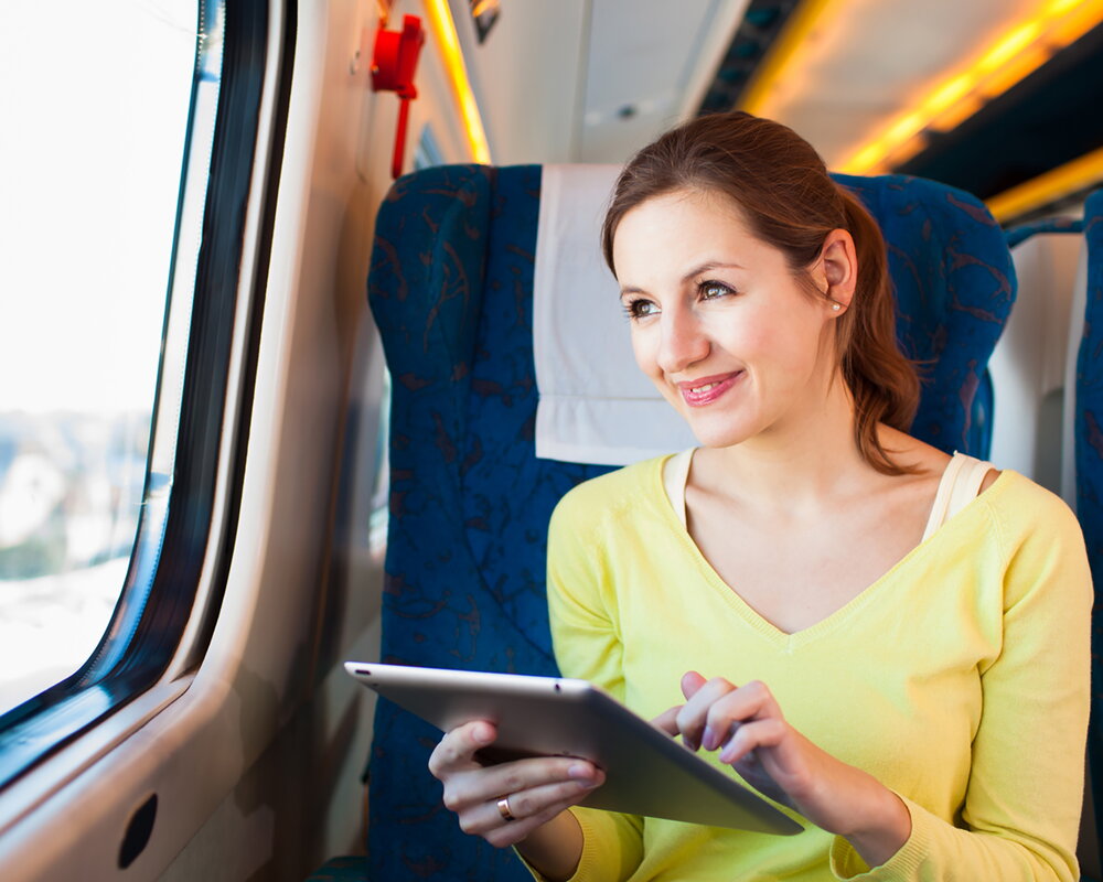 Meisje in trein werkt op iPad