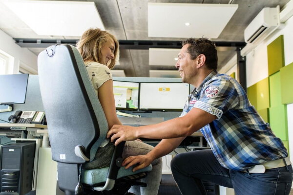 Thuiswerkanalyse Health2work - man onderzoekt of vrouw goede werkhouding heeft aan haar bureau