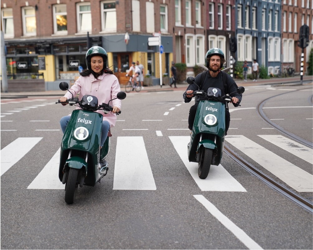 Twee mensen onderweg op elektrische scooters felyx
