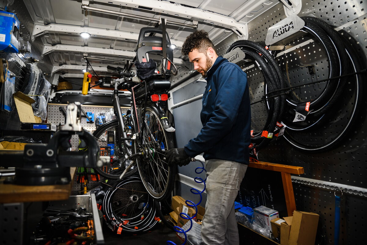 Fietsenmaker Lars walstock in zijn mobiele fietswerkplaats