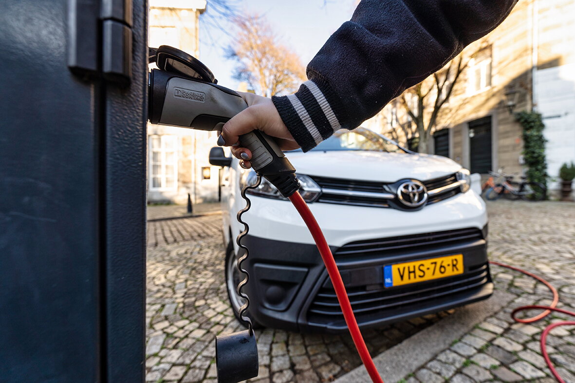 Stekker van elektrische bestelwagen wordt in laadpaal gestoken