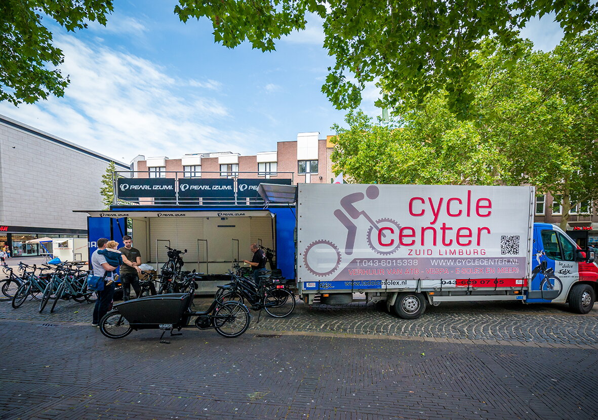 E-bikes op locatie van Cycle Center medewerker in gesprek met vader met kind bij elektrische bakfiets